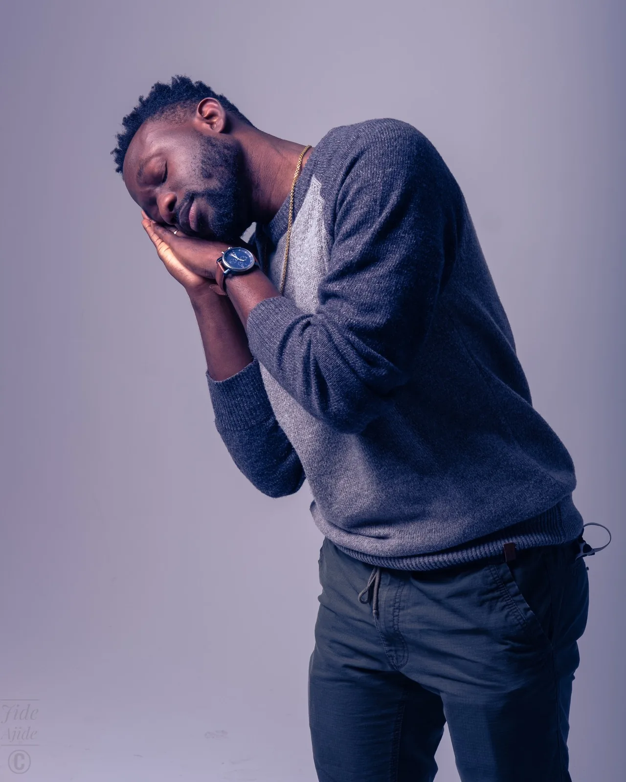 AJI, eyes closed, hands folded under his cheek